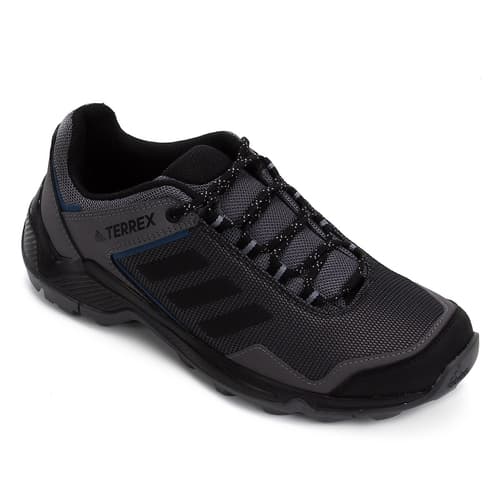 A foto mostra um pé do tênis Adidas, modelo Terrex, da cor preta.