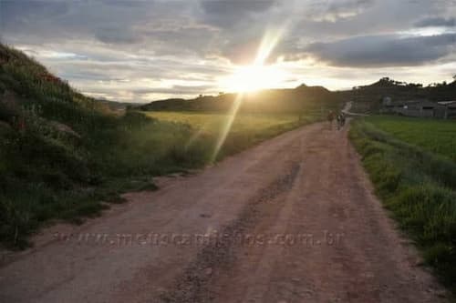Sol nascendo no Caminho de Santiago, pouco depois de Nájera. É possível ver alguns peregrinos caminhando no chão de terra batida.