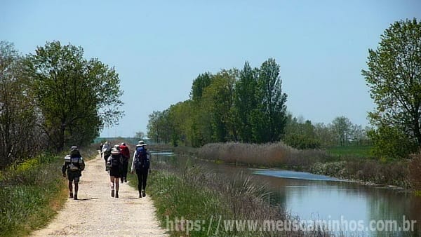 Peregrinos do Caminho de Santiago caminhando ao lado do Canal de Castilla