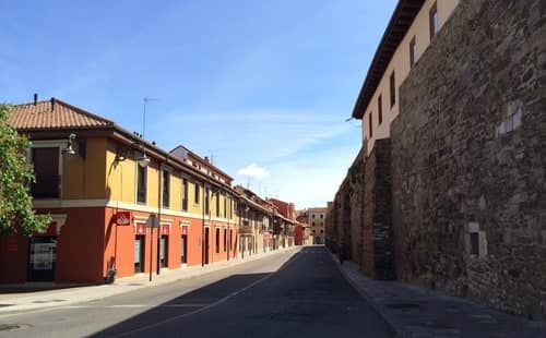 Foto mostrando uma rua com uma muralha de pedra, em Léon, Espanha.