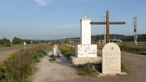 Foto da trilha para peregrinos na etapa entre Astorga e Rabanal del Camino. Ao lado da trilha, duas cruzes e a indicação dos pueblos pelos quais o peregrino pasará.