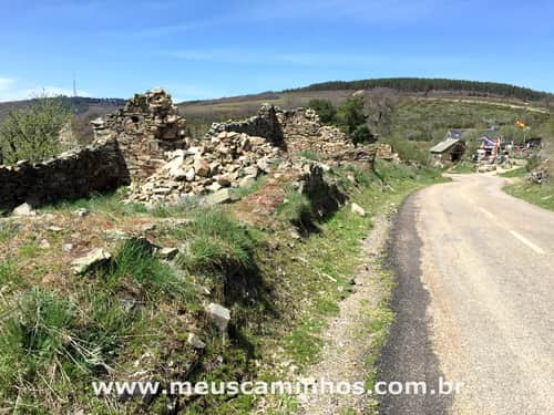 Foto mostra uma estrada o albergue de Manjarin ao fundo, no Caminho de Santiago.